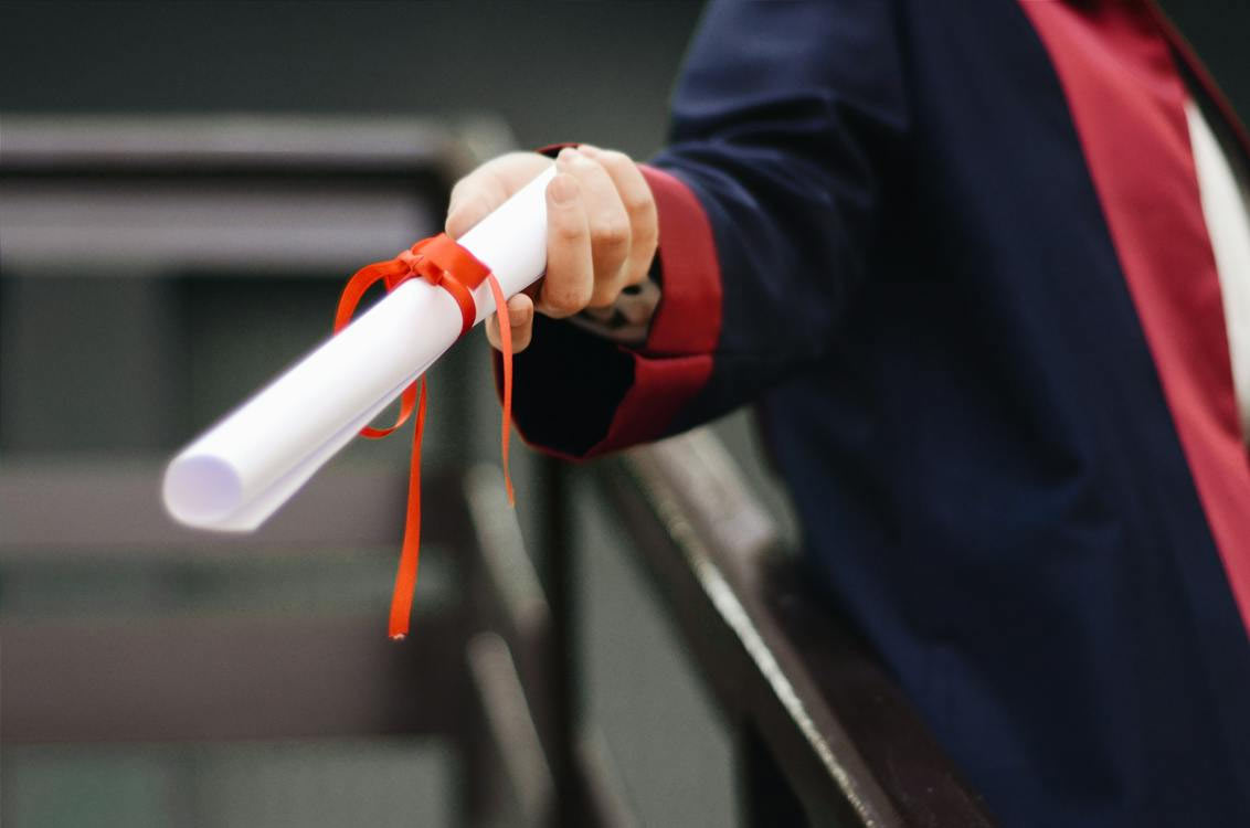 Someone giving a graduation diploma